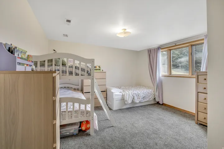 Bedroom featuring light colored carpet and baseboards