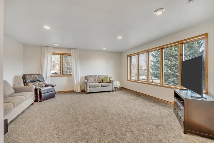 Living room with light colored carpet and recessed lighting