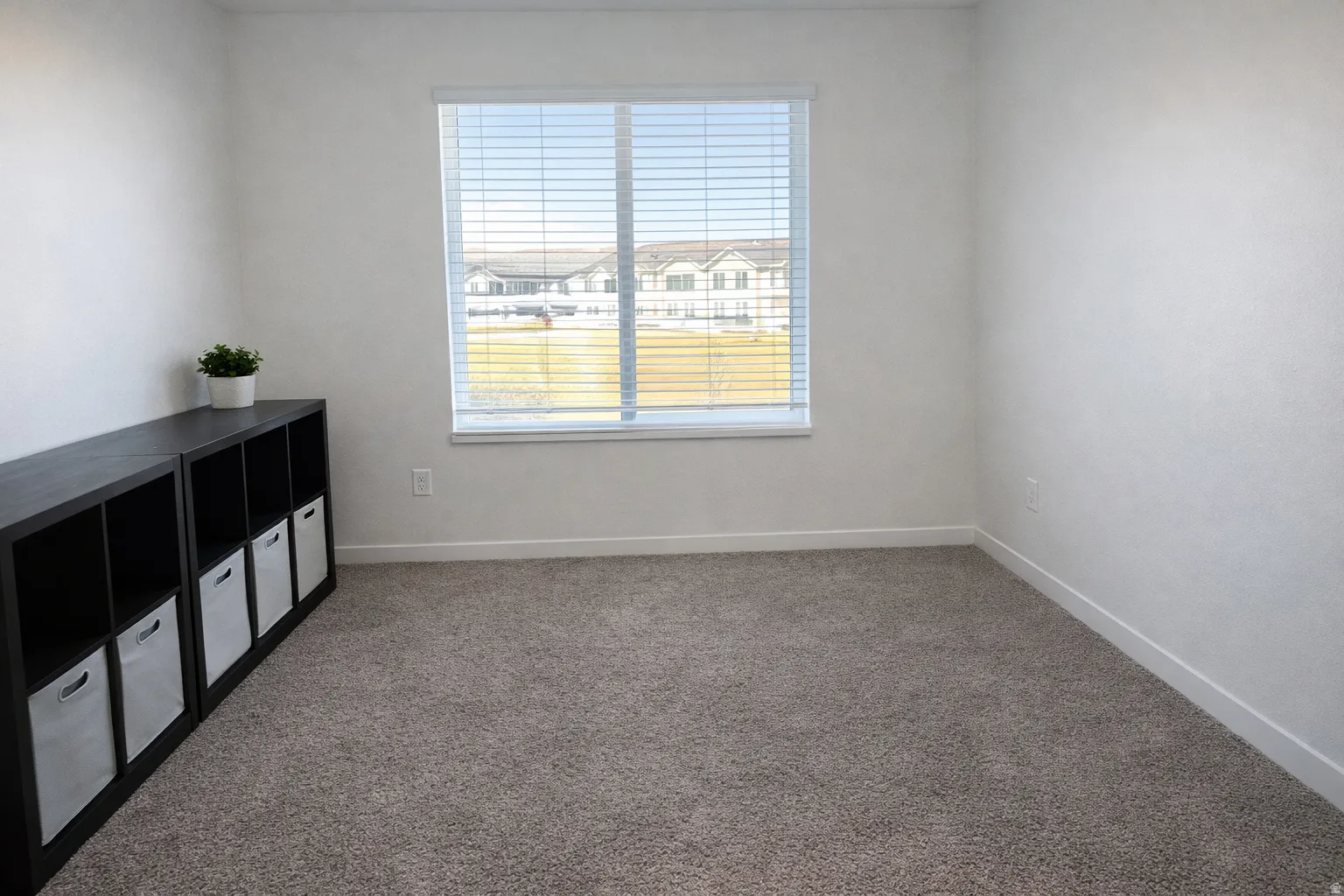 Empty room featuring light carpet and a residential view