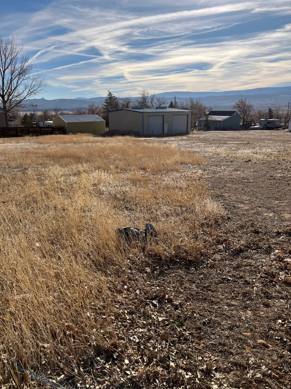 View of yard featuring an outdoor structure, a mountain view, a garage, and a view of countryside