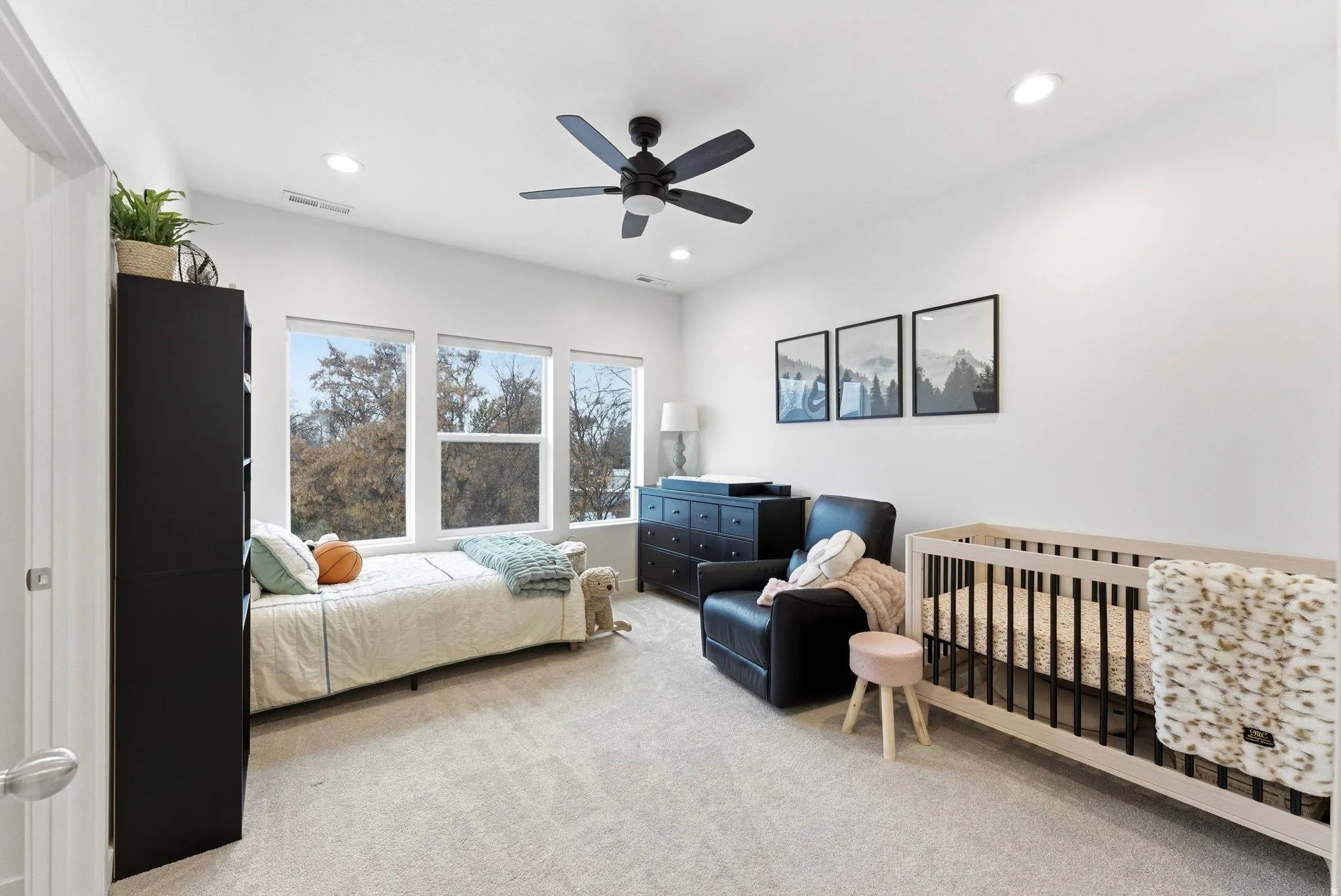 Bedroom featuring light colored carpet, a ceiling fan, recessed lighting, and a nursery area