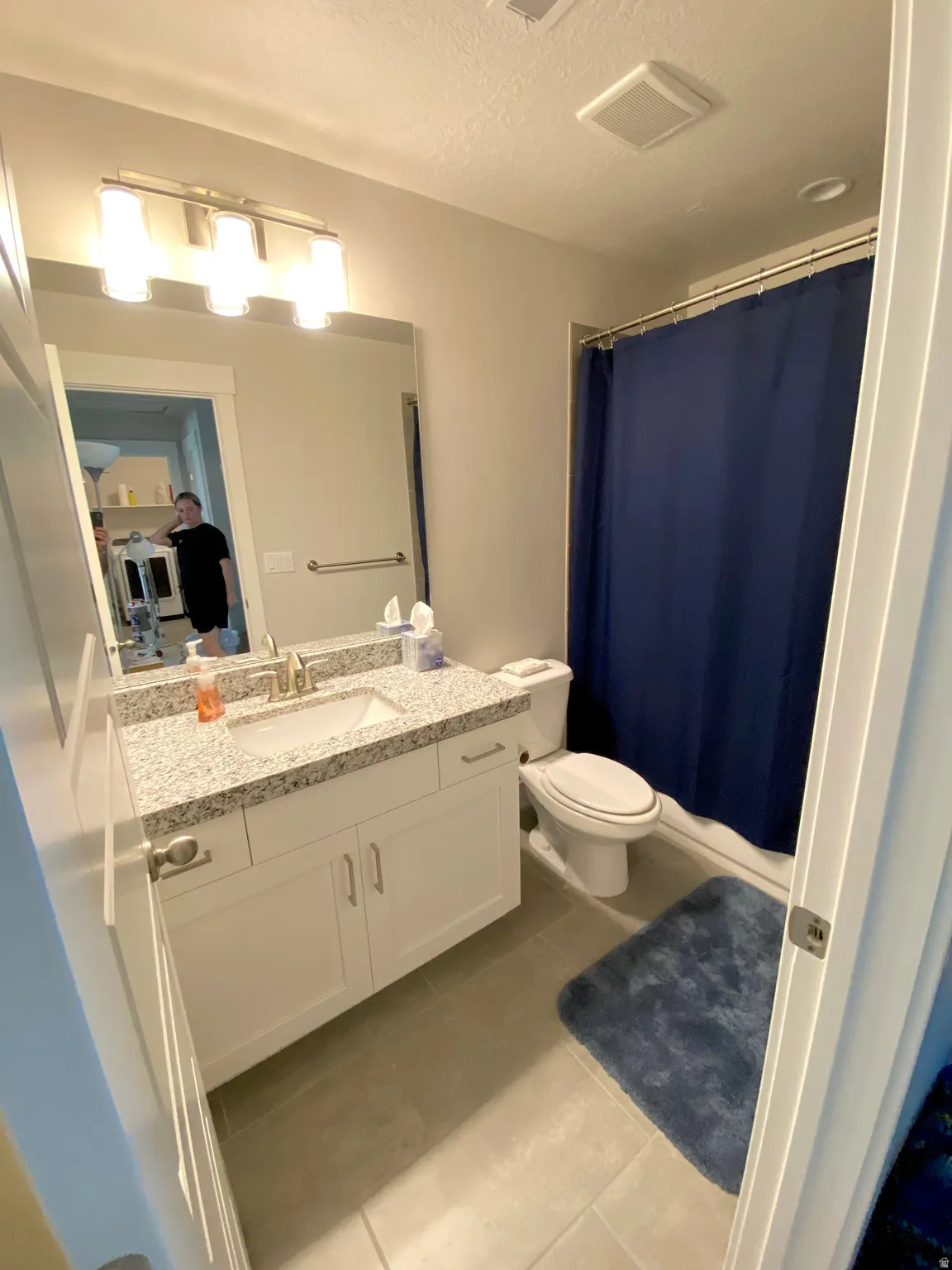 2nd Bathroom with our cleaner in the mirror checking our her work.