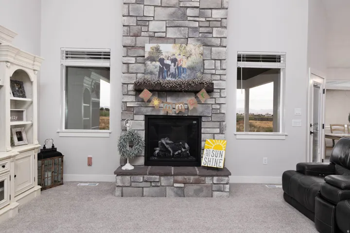 Carpeted living room featuring a high ceiling and a fireplace
