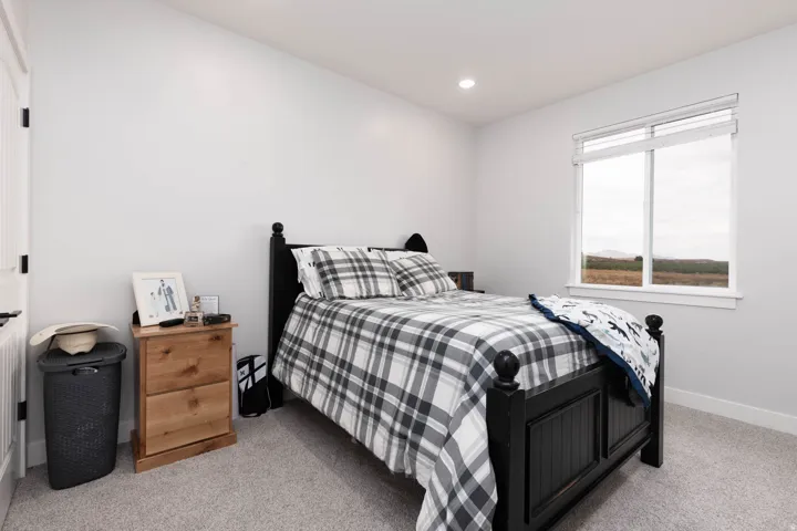 Bedroom with light colored carpet and recessed lighting