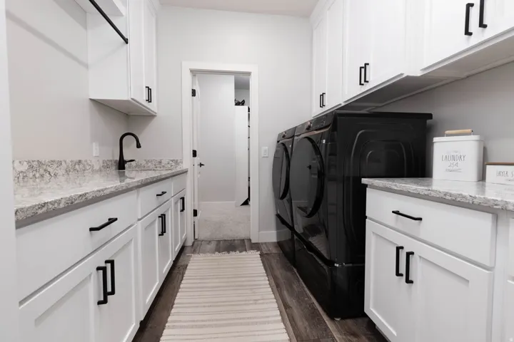 Laundry area featuring cabinet space, dark wood finished floors, and washer and dryer