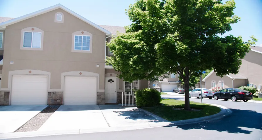 View of front of property with driveway, a garage, stone siding, and stucco siding