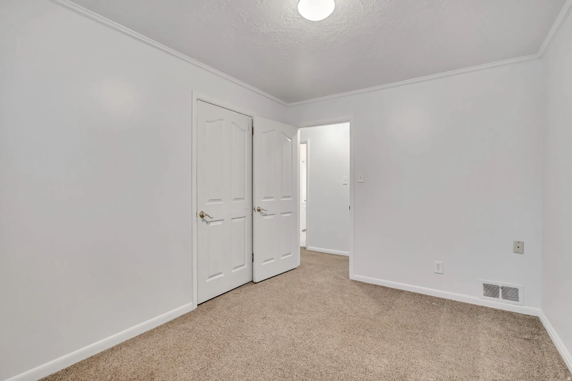 Main-level bedroom featuring neutral finishes, closet storage, and flexible layout for primary, guest, or office use.