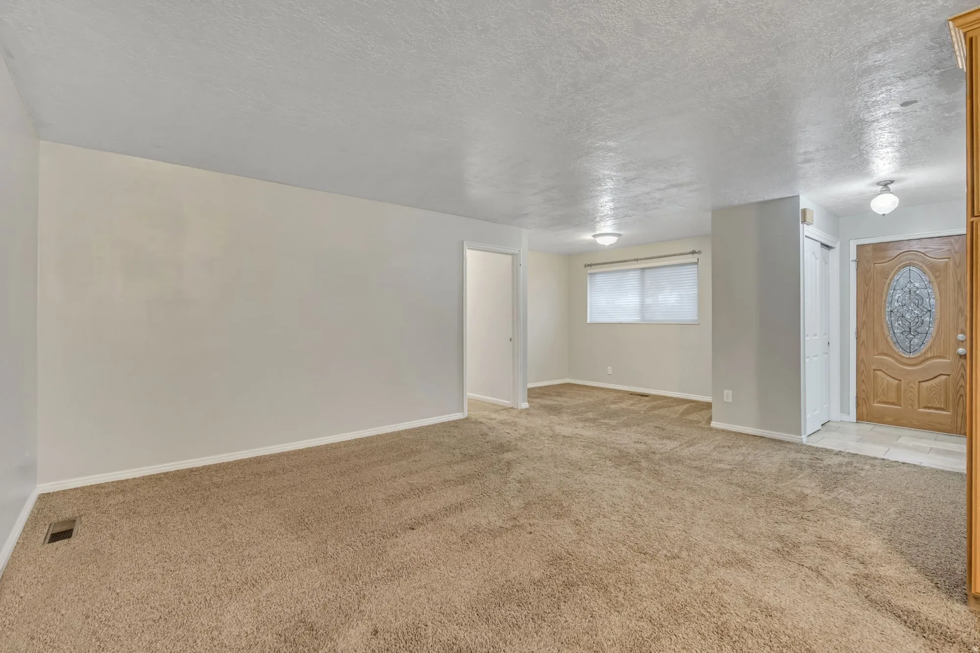 Spacious main living area with open layout and direct access to the entry, offering flexible configuration for seating, dining, or entertaining.