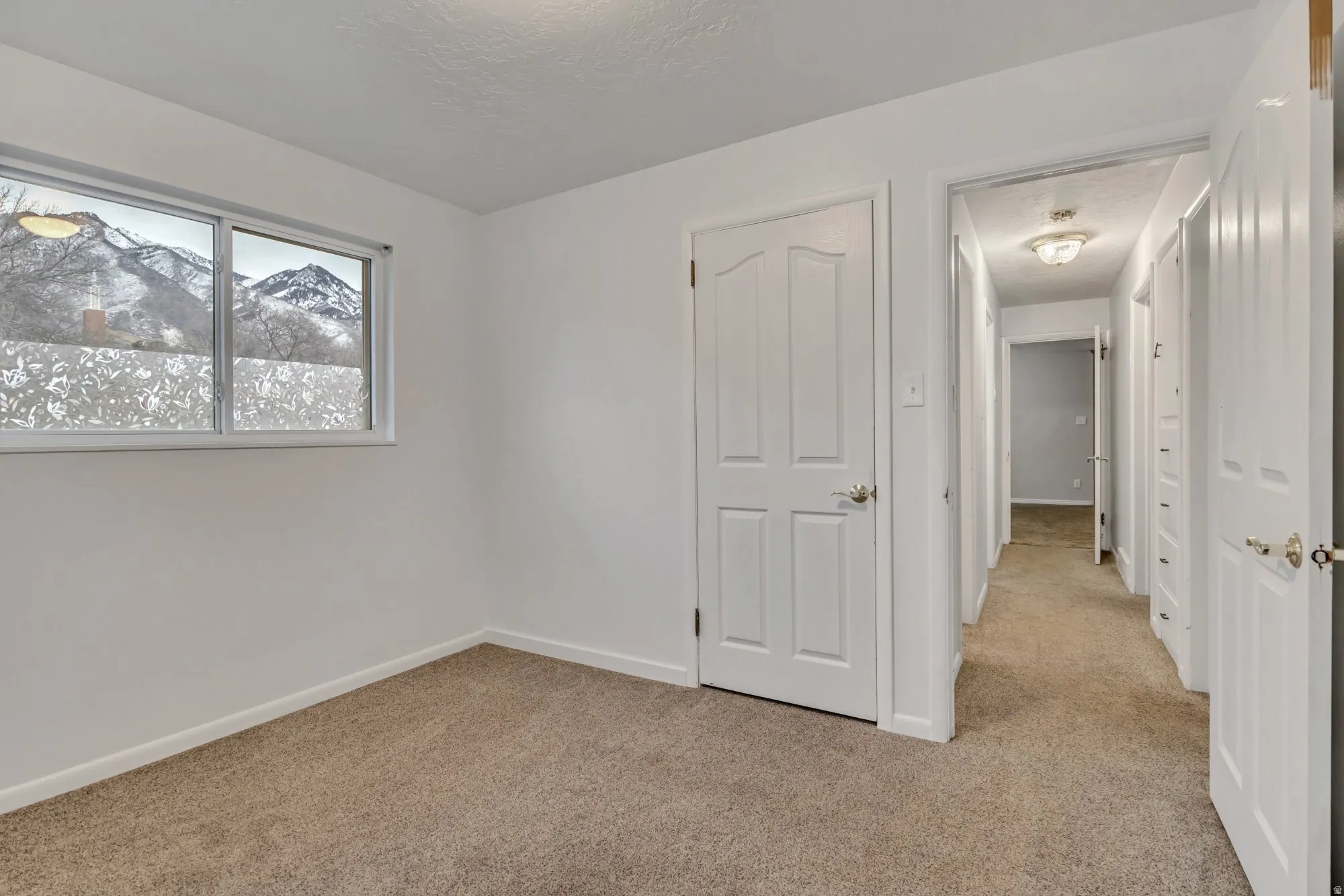 Bright main-level bedroom with natural light and clean finishes, part of the functional 3-bedroom upstairs layout.