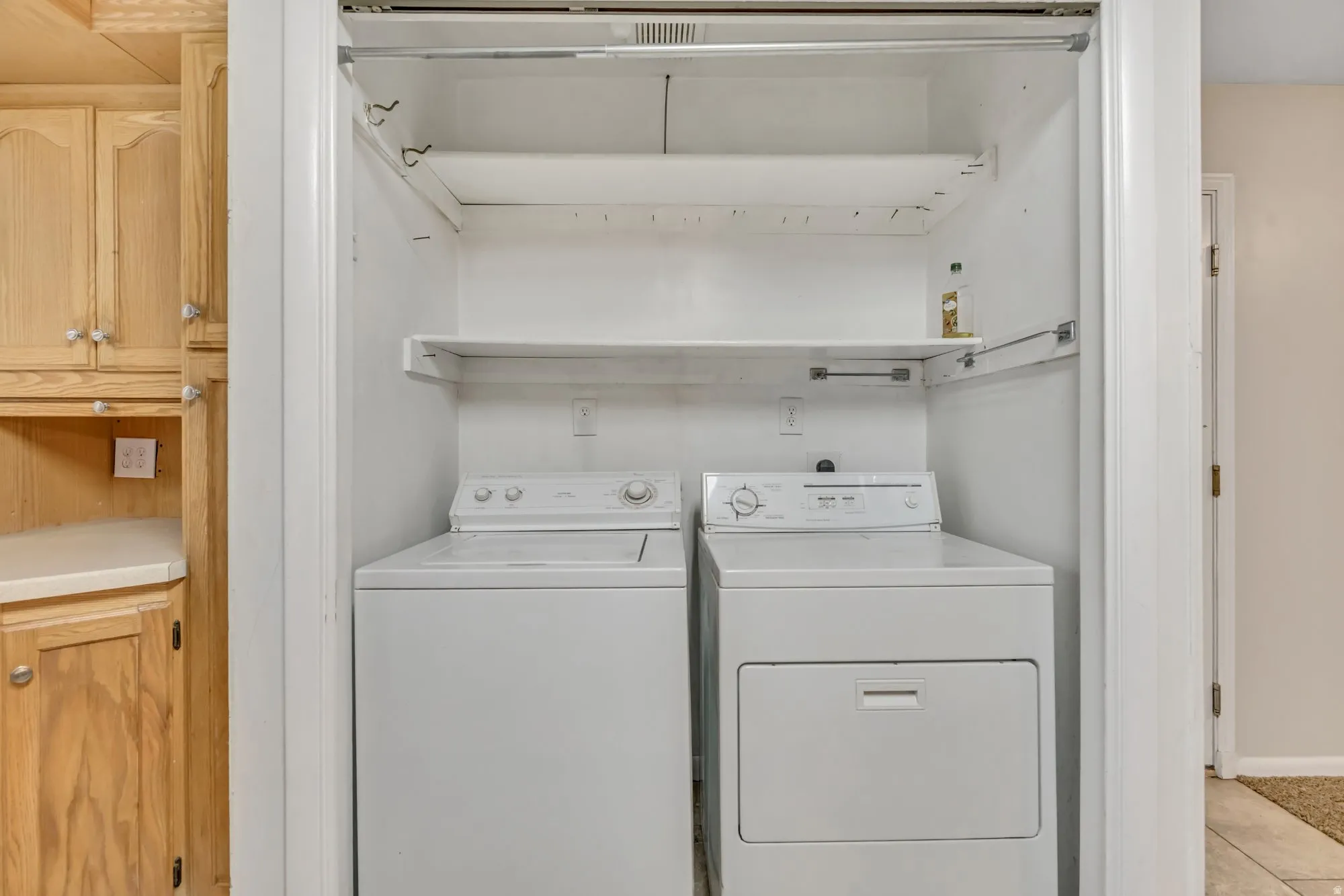 Dedicated laundry room with washer and dryer included, plus built-in shelving for convenient storage and organization.