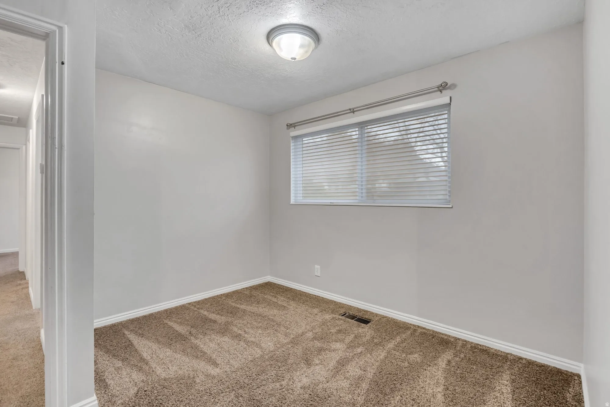 Comfortable bedroom with natural light and clean lines, offering adaptable space for sleeping, workspace, or rental configuration.