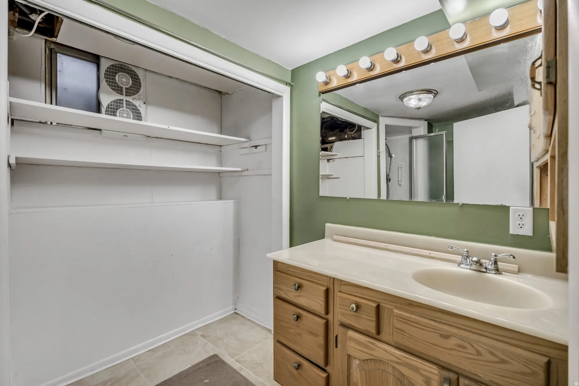 Bathroom with extended vanity storage and tiled tub/shower surround, conveniently serving the upstairs bedroom layout.