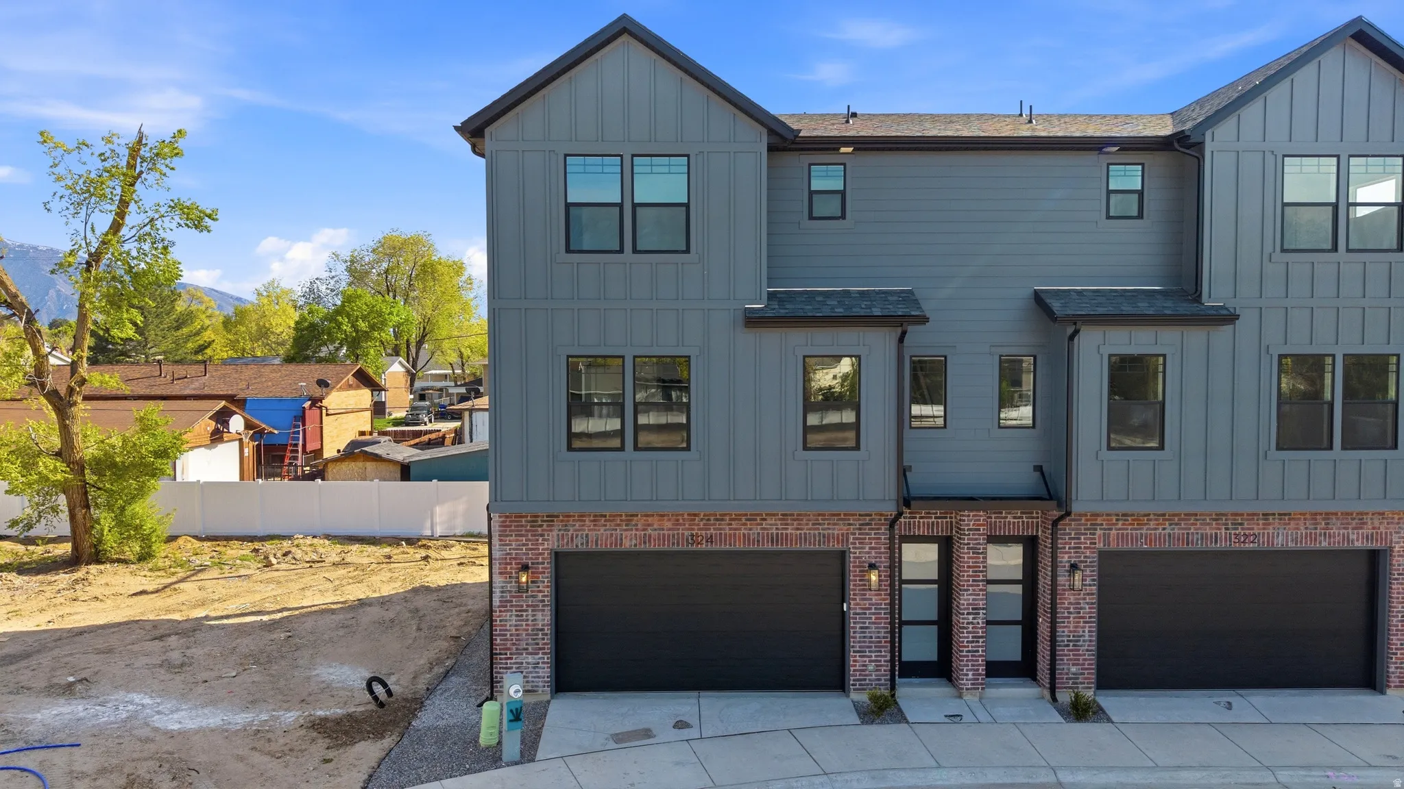 View of front of property with board and batten siding, an attached garage, and concrete driveway