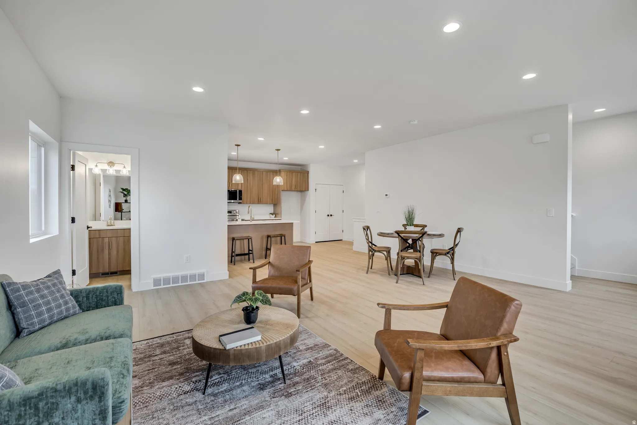 Living area with light wood-style flooring and recessed lighting
