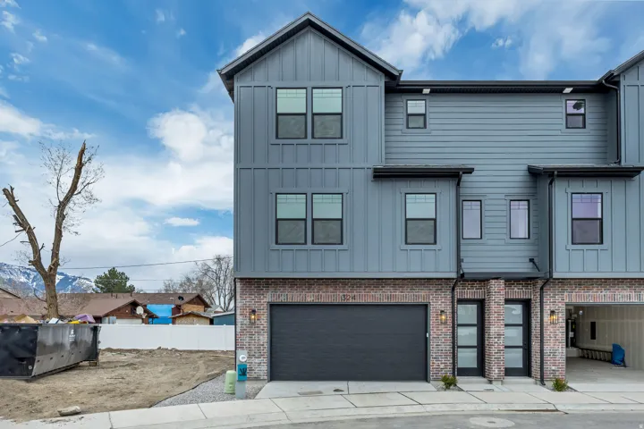 View of front of property with board and batten siding and an attached garage