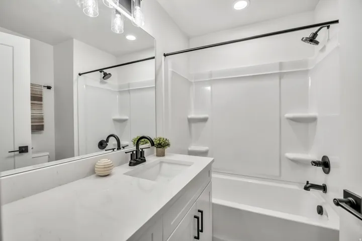Bathroom featuring vanity, bathtub / shower combination, and recessed lighting