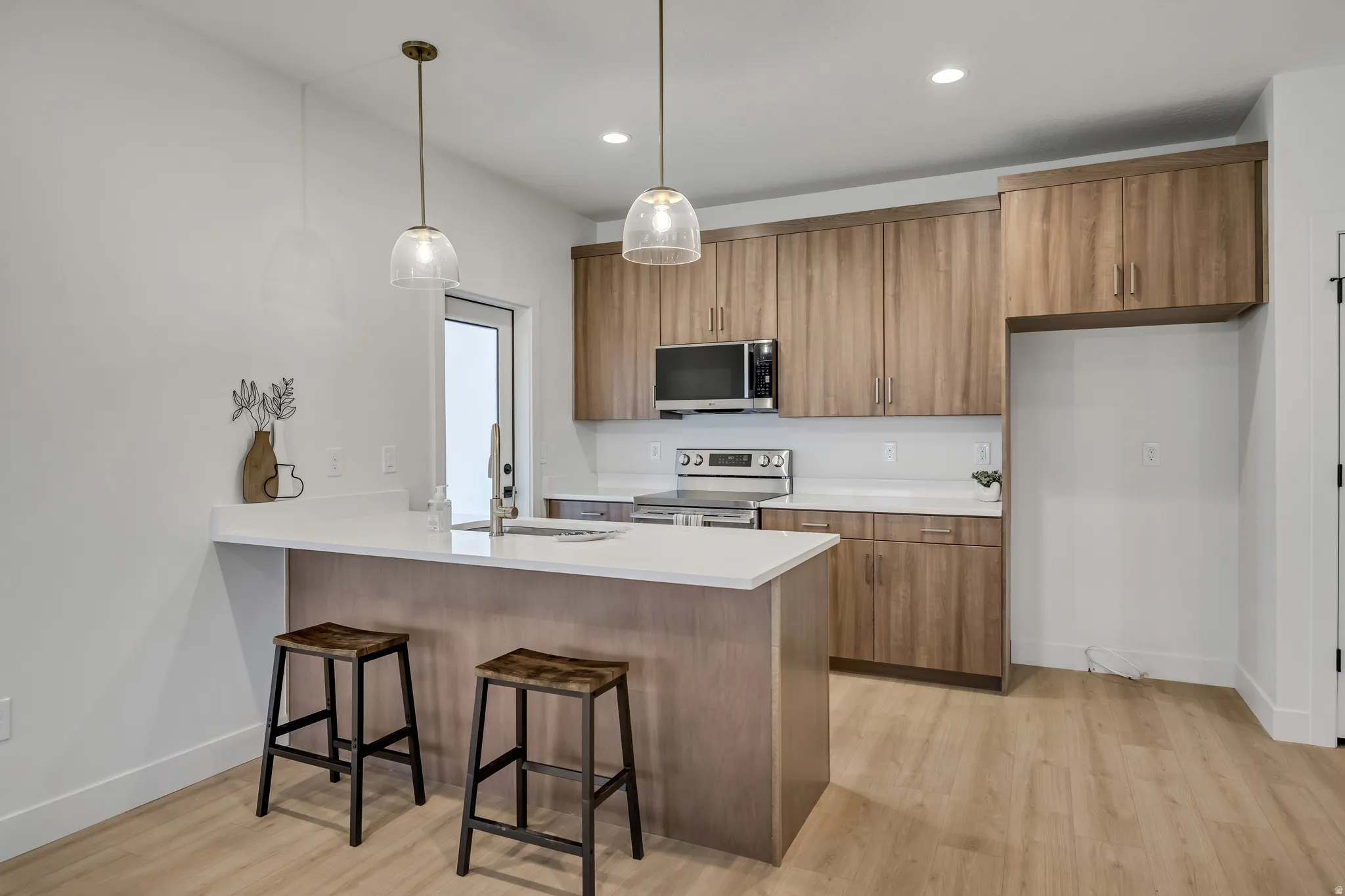 Kitchen featuring a kitchen breakfast bar, wood finish cabinetry, and stainless steel appliances