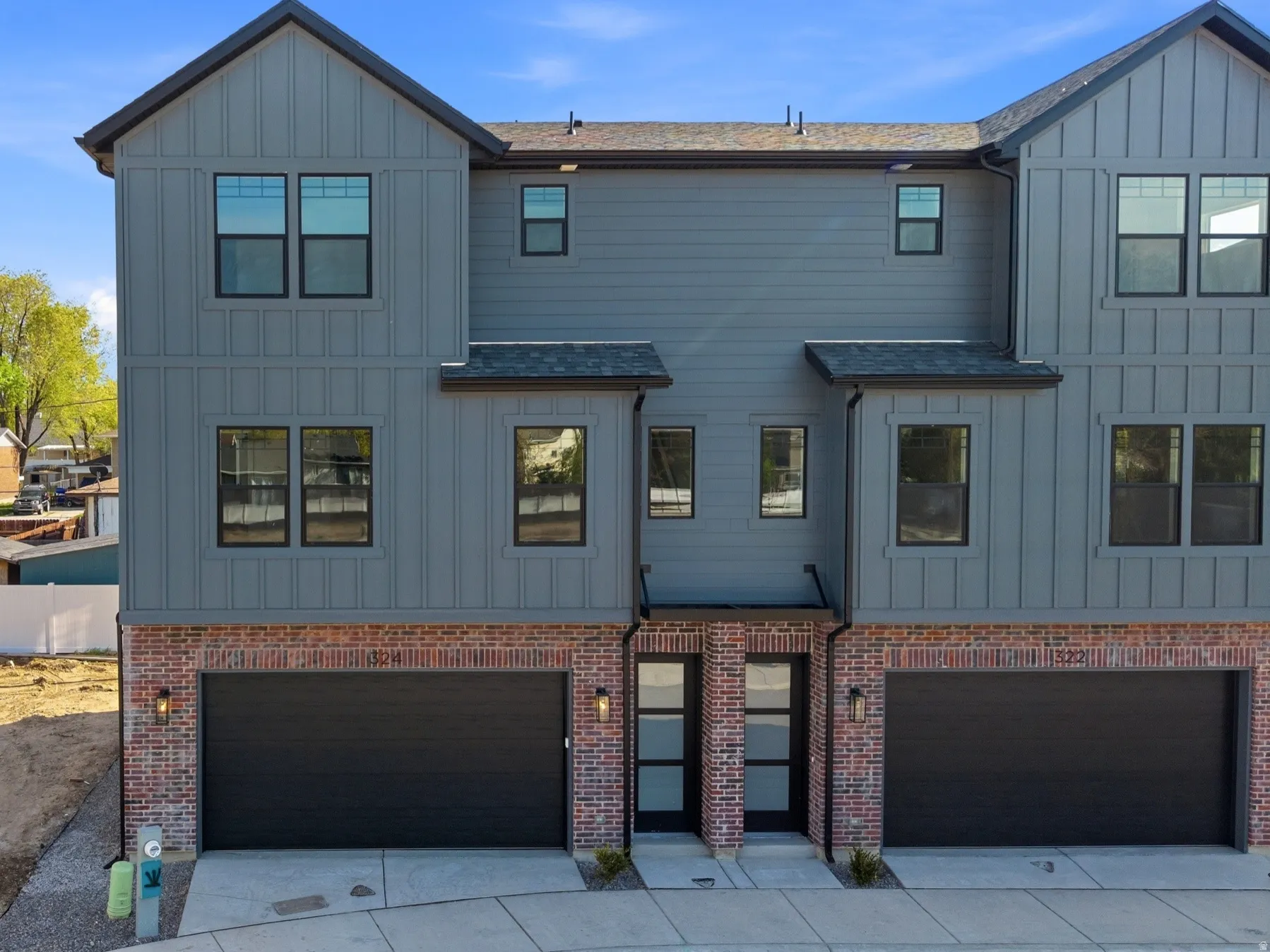 View of front of property with board and batten siding, an attached garage, and concrete driveway