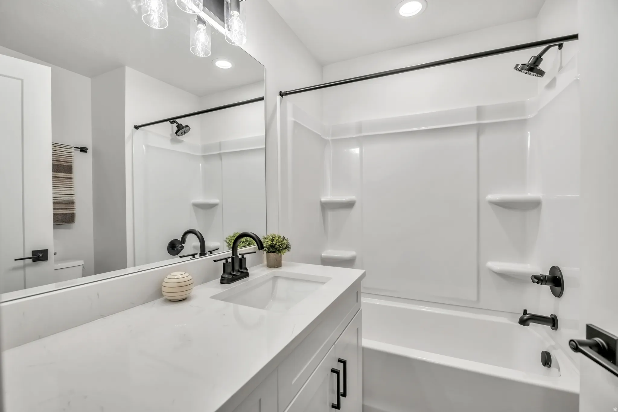 Bathroom featuring vanity, bathtub / shower combination, and recessed lighting