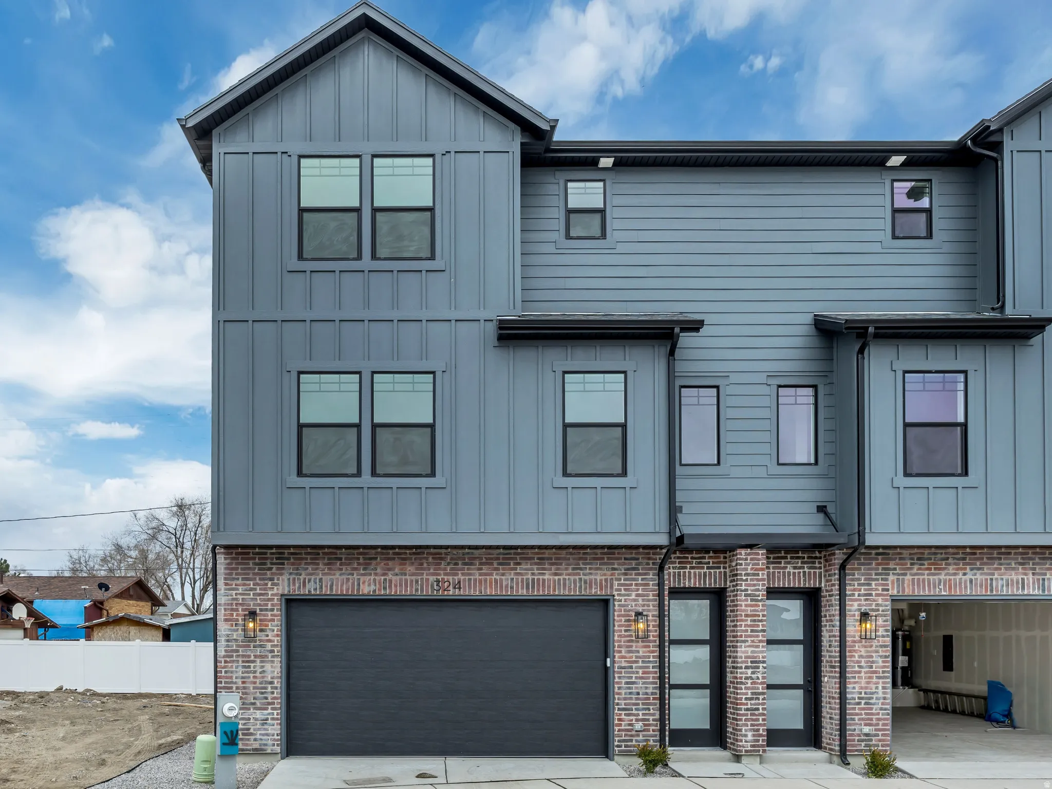 View of front of property with board and batten siding and an attached garage