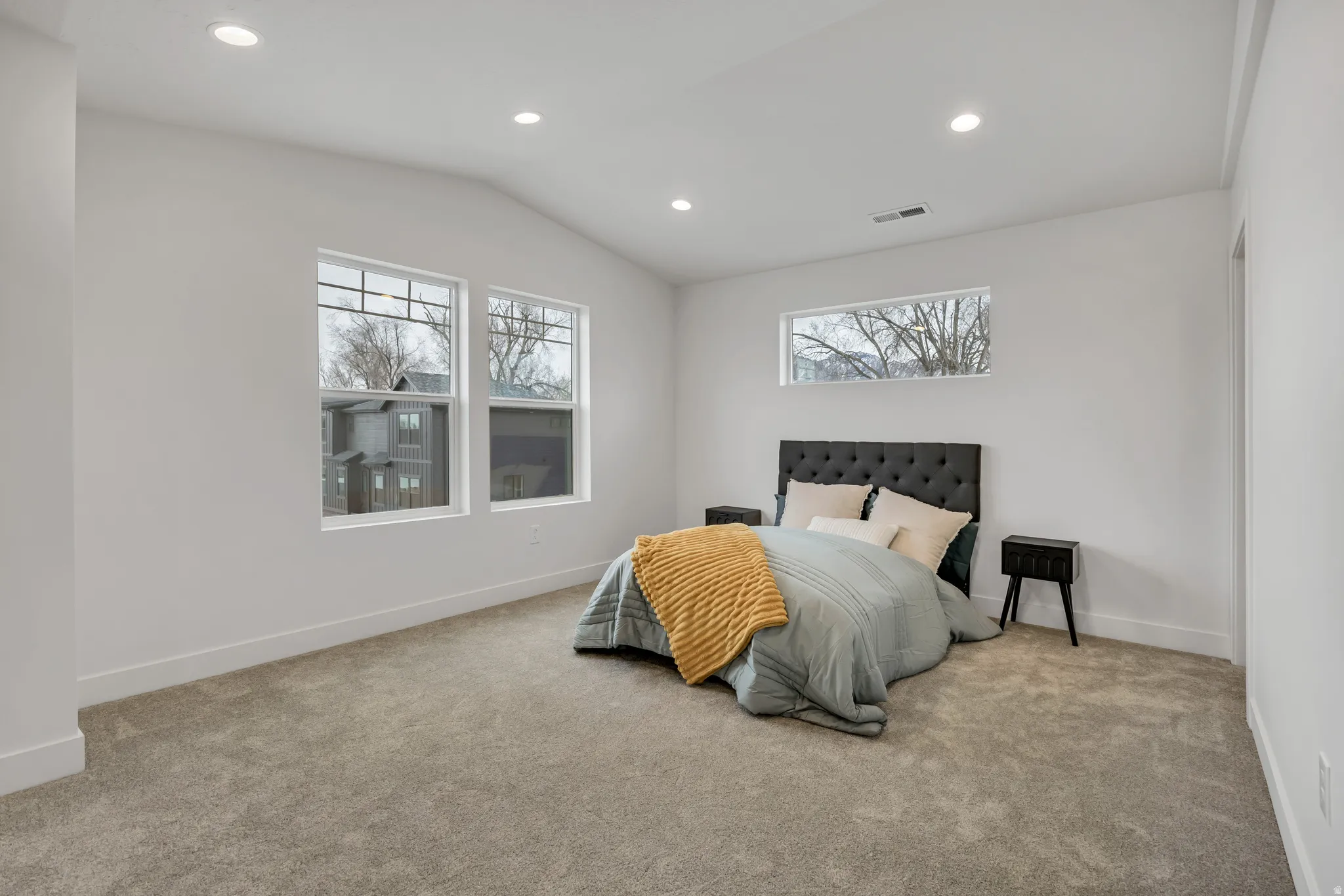 Carpeted bedroom featuring recessed lighting, lofted ceiling, and multiple windows