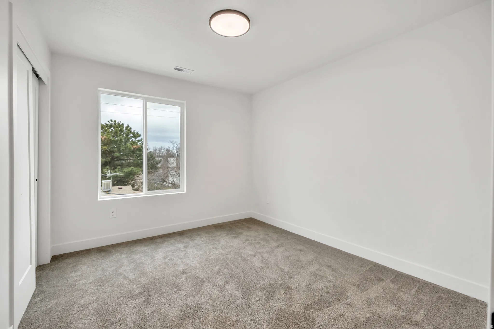 Unfurnished bedroom featuring light colored carpet and a closet