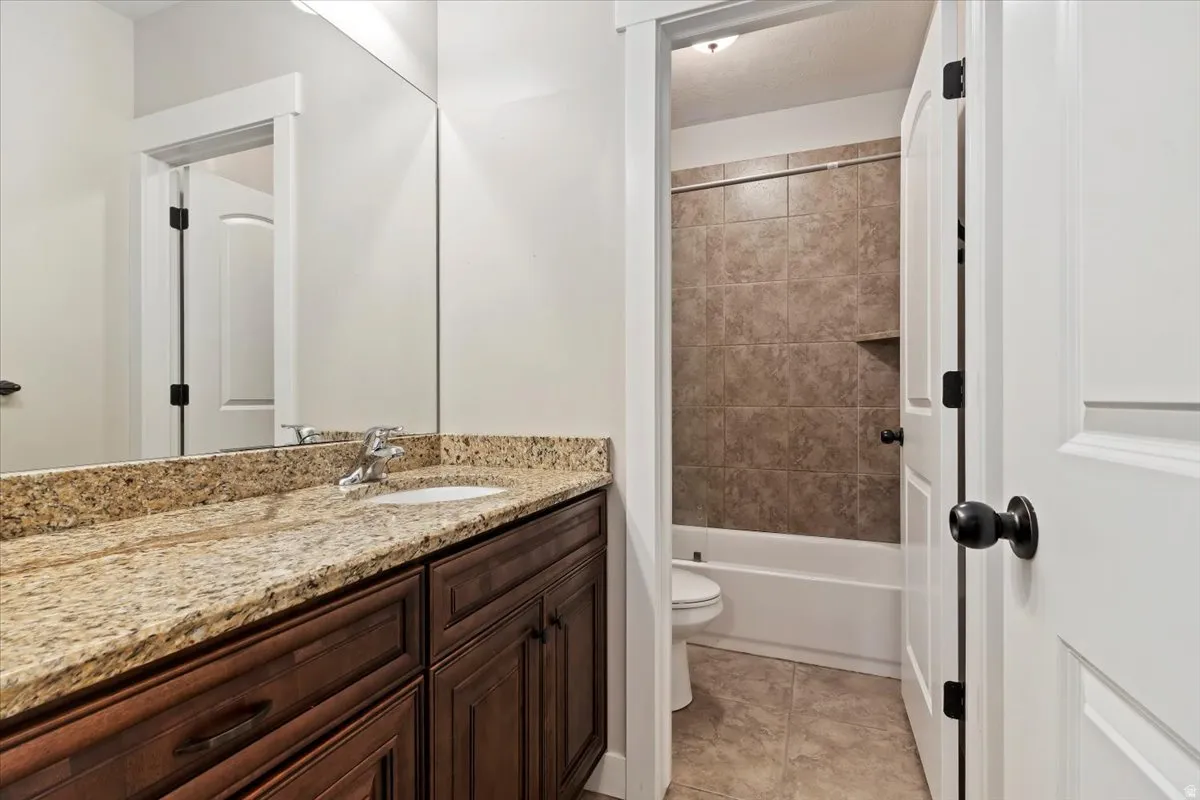 Full bath with vanity, shower / washtub combination, and light tile patterned flooring