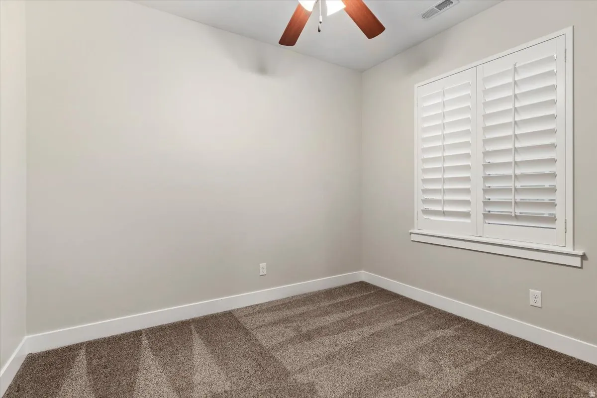 Spare room featuring carpet floors and a ceiling fan