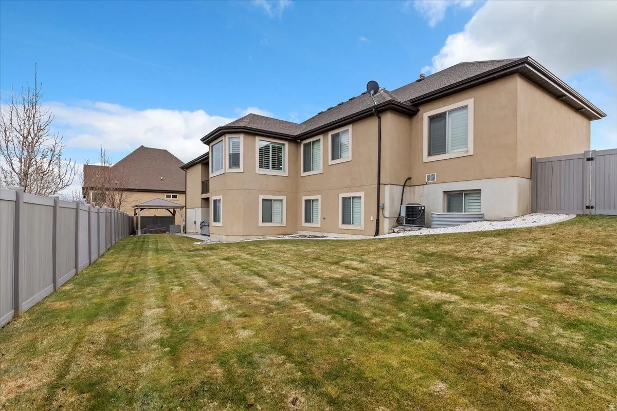 Rear view of house featuring a fenced backyard, a patio, and stucco siding