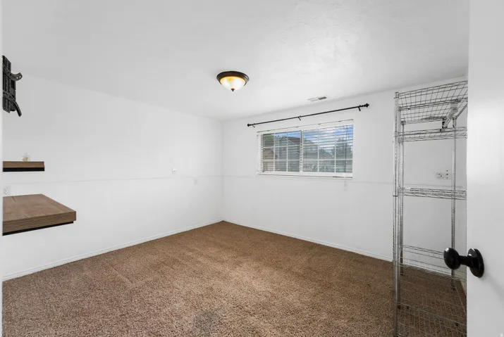Carpeted spare room with baseboards