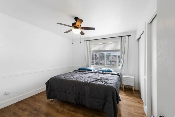Bedroom with hardwood / wood-style floors, a closet, and ceiling fan