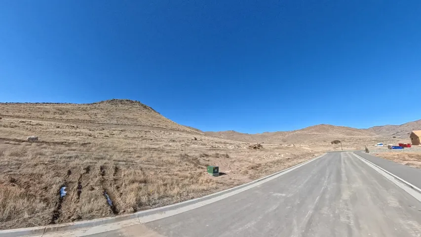 View of asphalt road featuring a mountain view and curbs