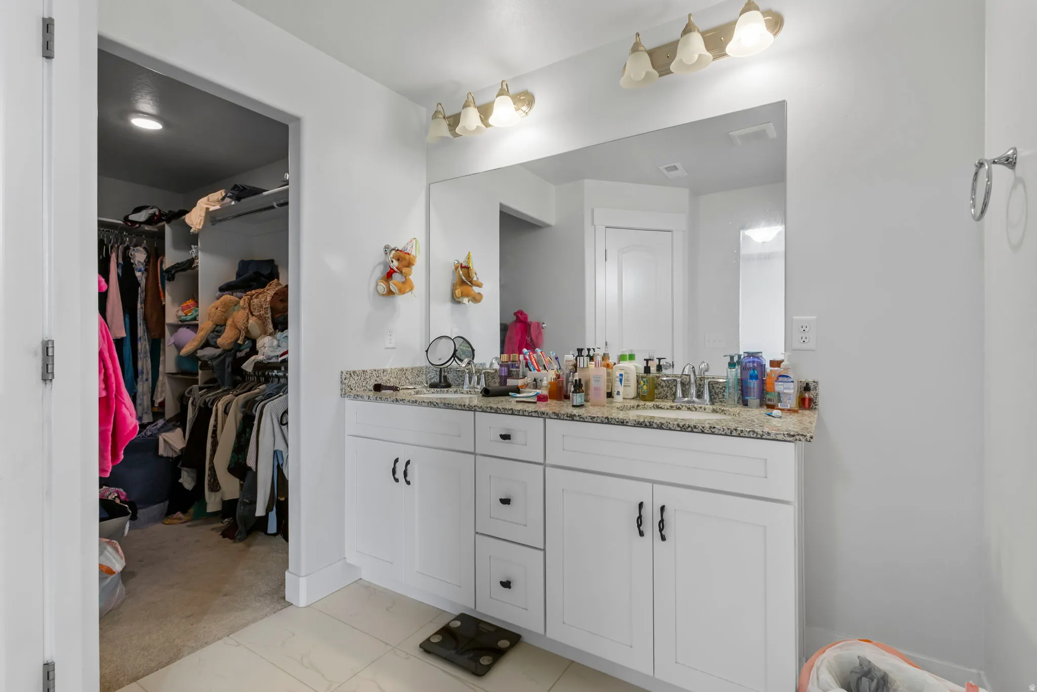 Full bath featuring double vanity and a walk in closet