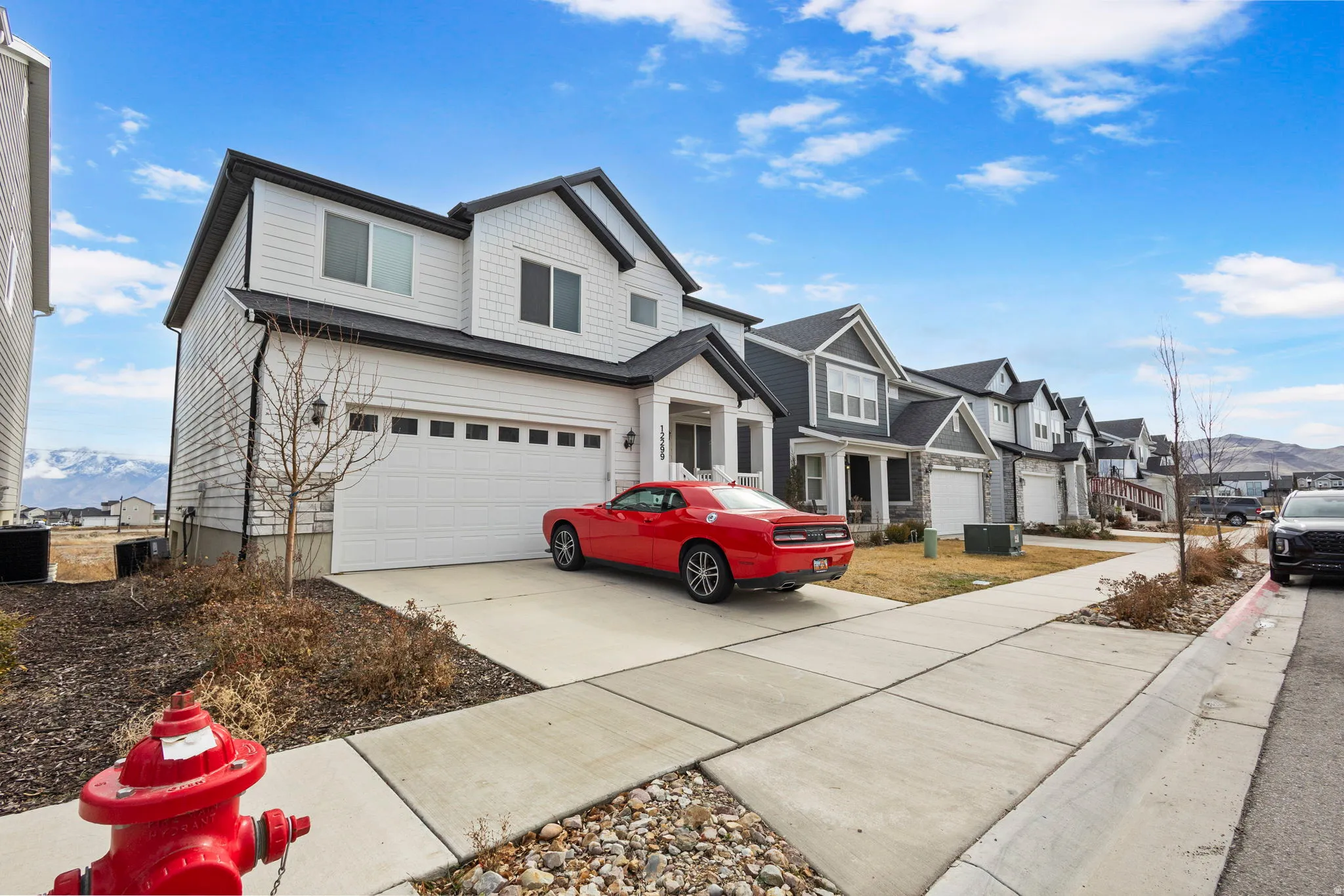 View of front of house with concrete driveway, a garage, a mountain view, and a residential view