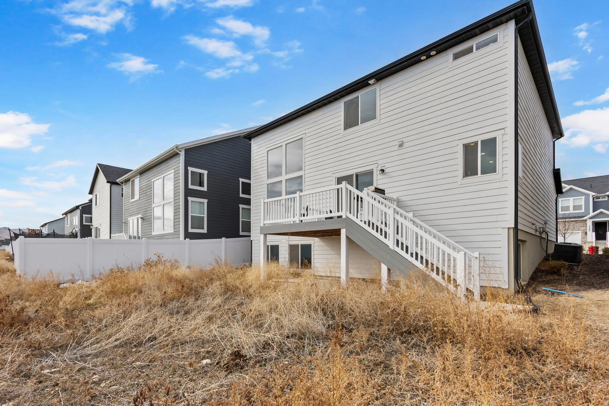 Rear view of house featuring stairs and a deck