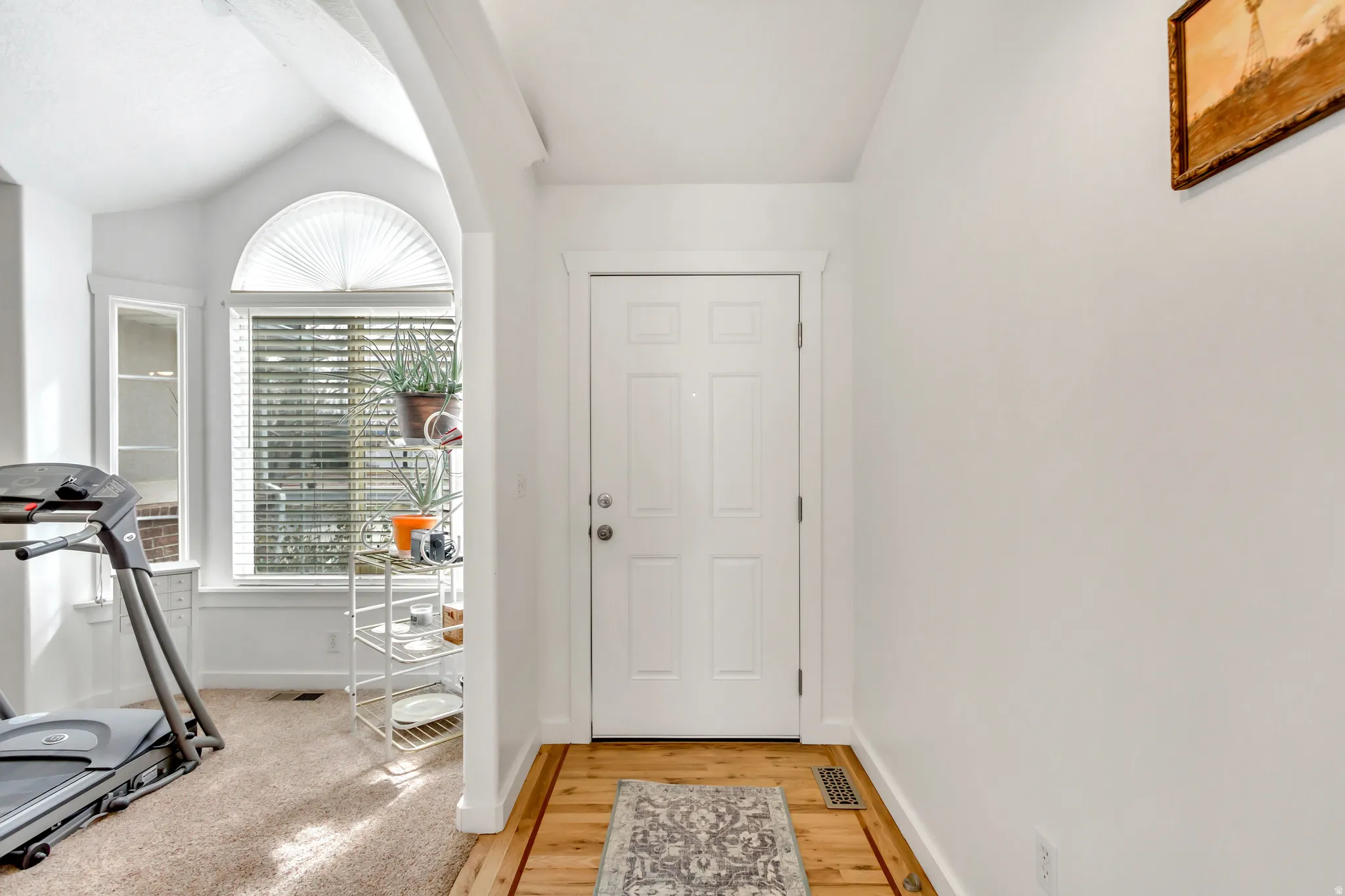 Foyer featuring vaulted ceiling and light wood-style floors