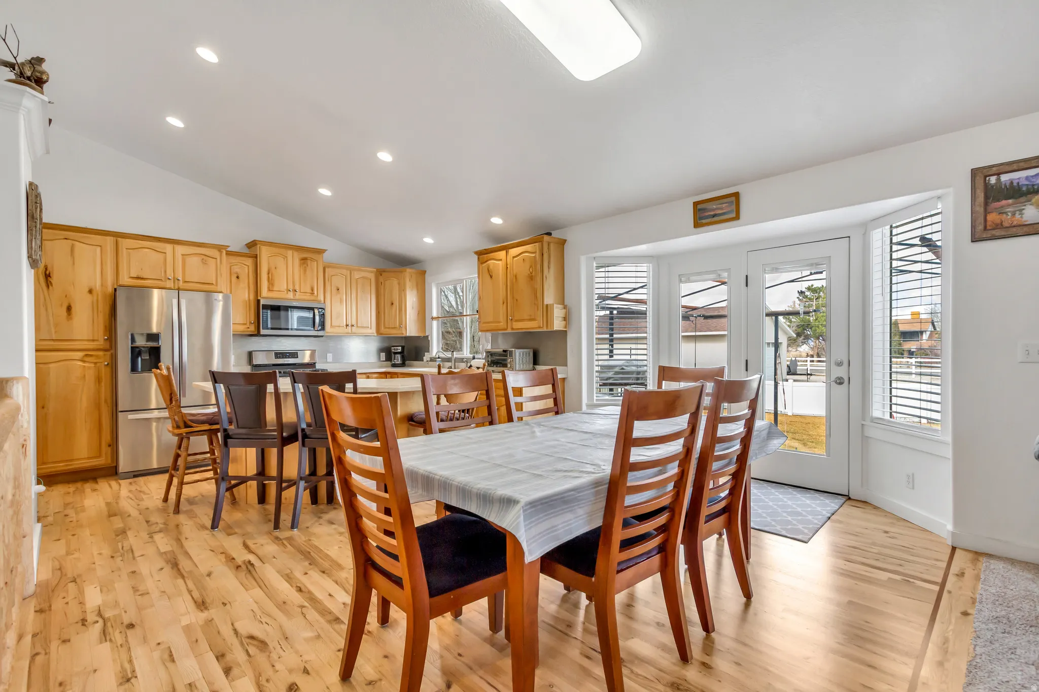 Dining space featuring recessed lighting, vaulted ceiling, and light wood-style floors