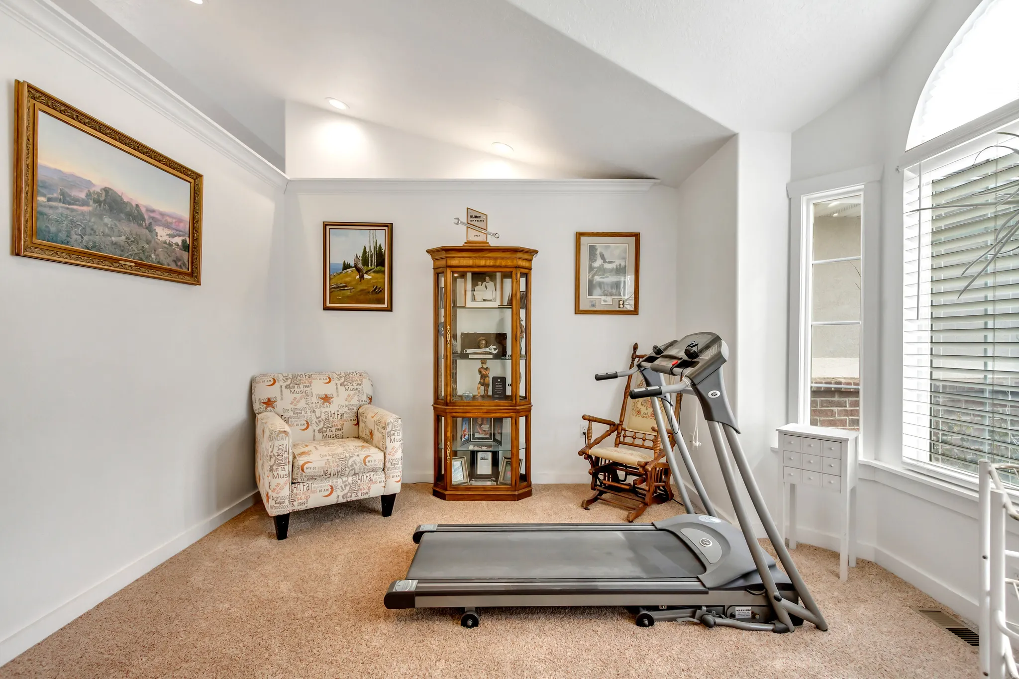 Workout area featuring lofted ceiling and light carpet