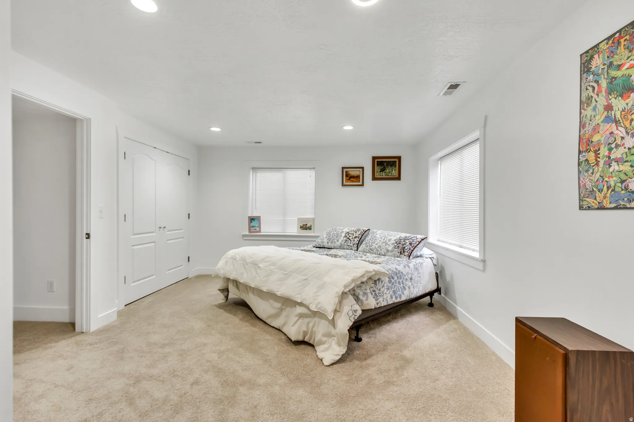 Bedroom featuring light colored carpet, recessed lighting, and a closet