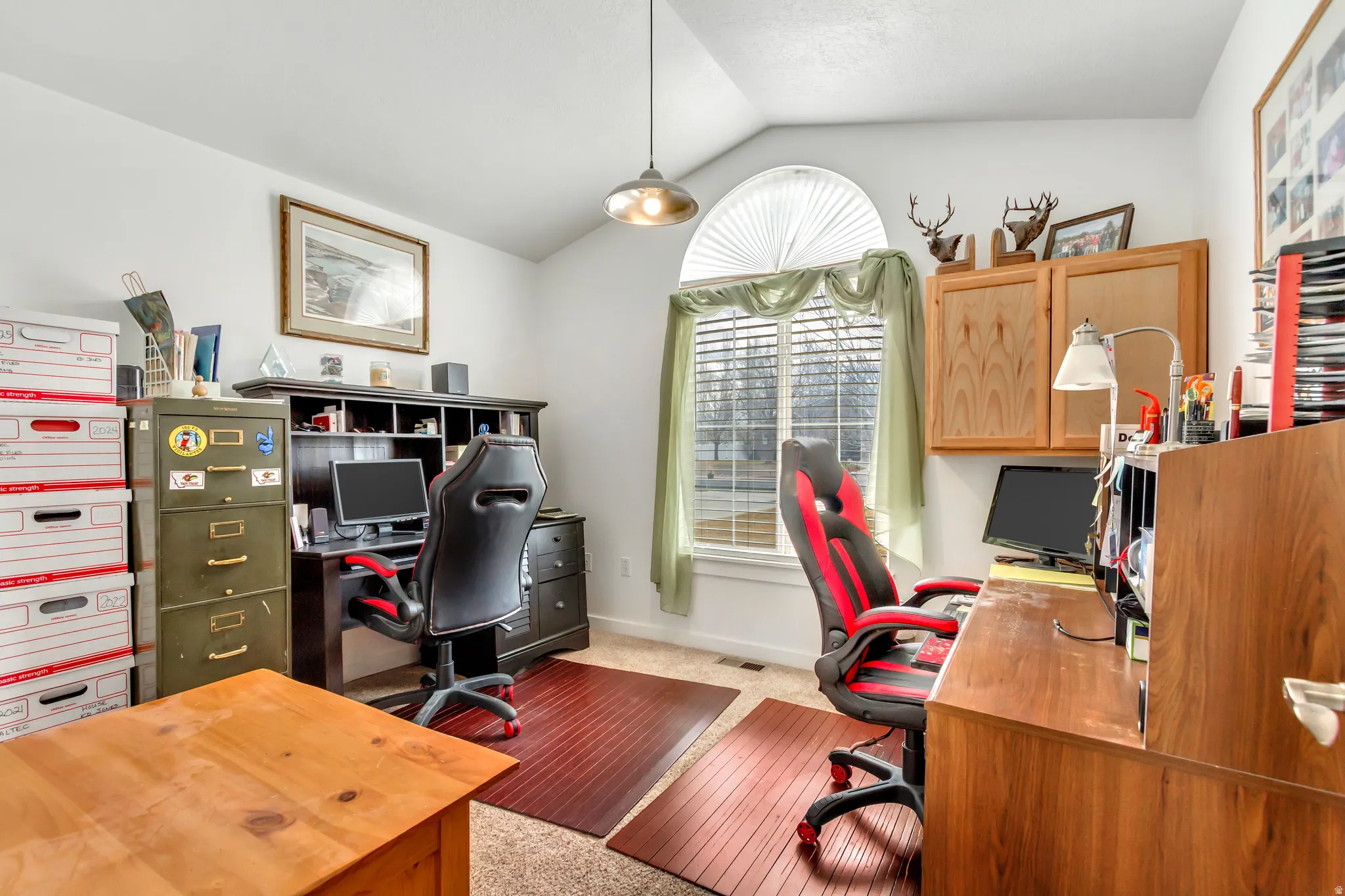 Office area with lofted ceiling and light carpet