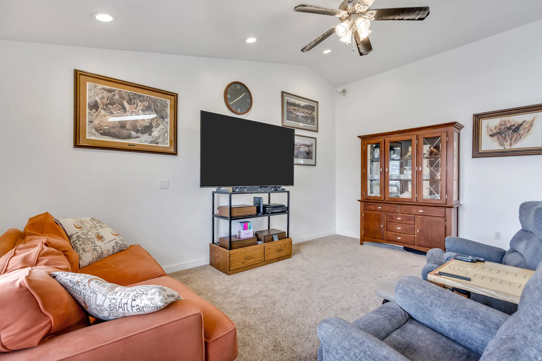 Carpeted living room with a ceiling fan, lofted ceiling, and recessed lighting