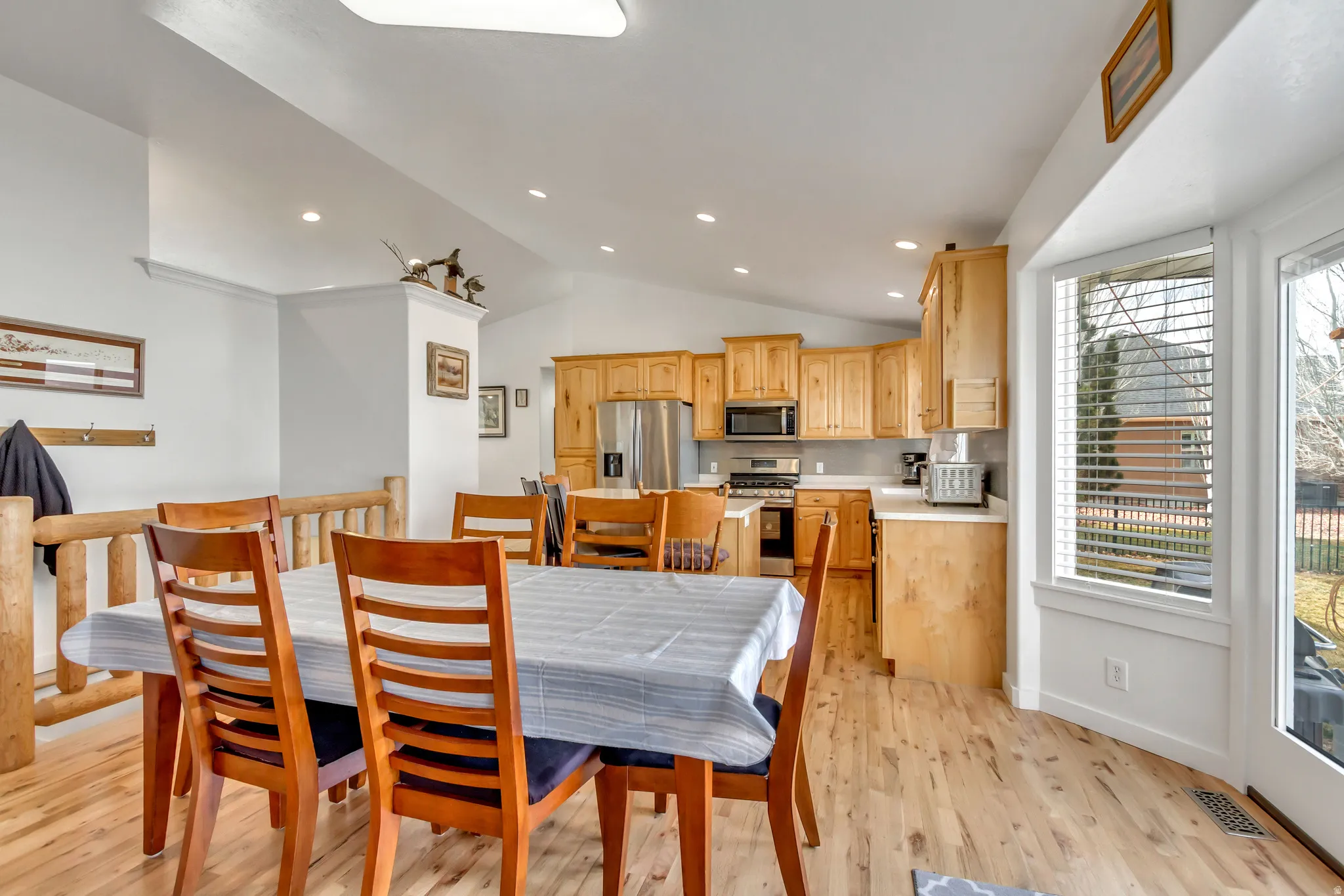 Dining area with lofted ceiling, light wood-type flooring, and recessed lighting