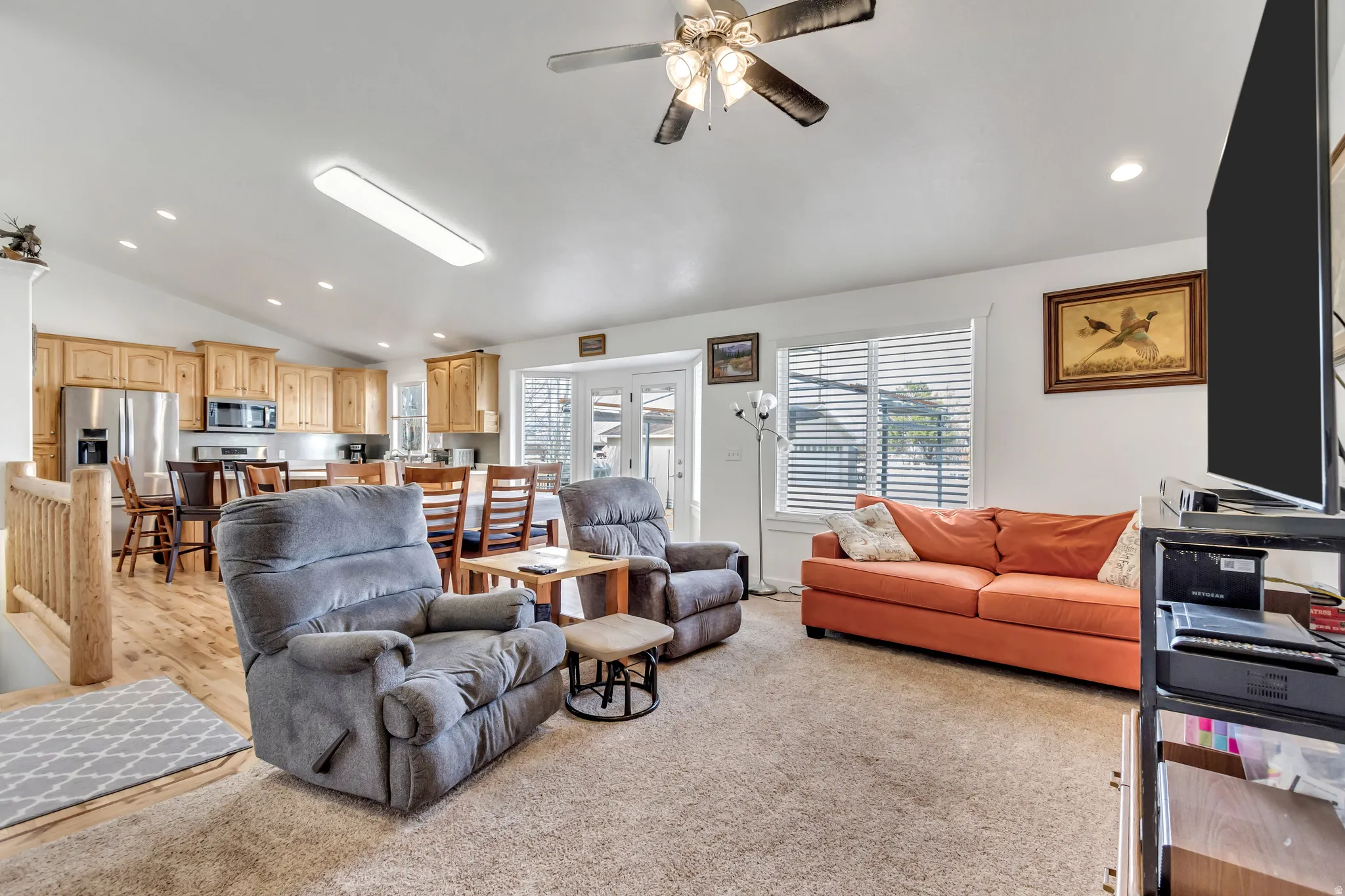 Living room with recessed lighting, vaulted ceiling, ceiling fan, and light colored carpet