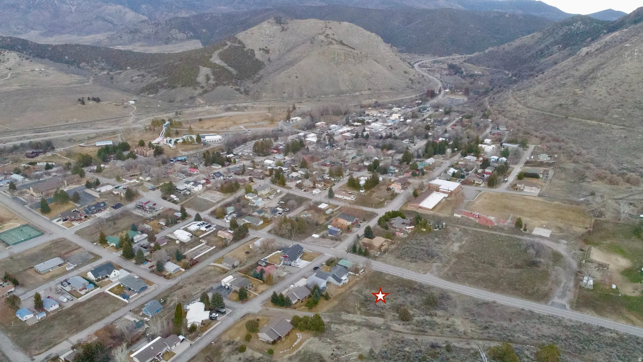 Aerial view of property's location featuring a mountainous background and nearby suburban area