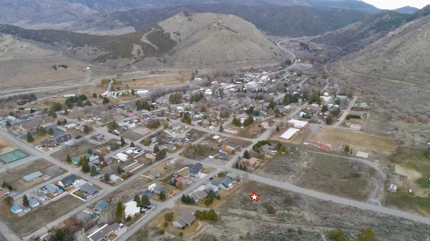 Aerial view of property's location featuring a mountainous background and nearby suburban area