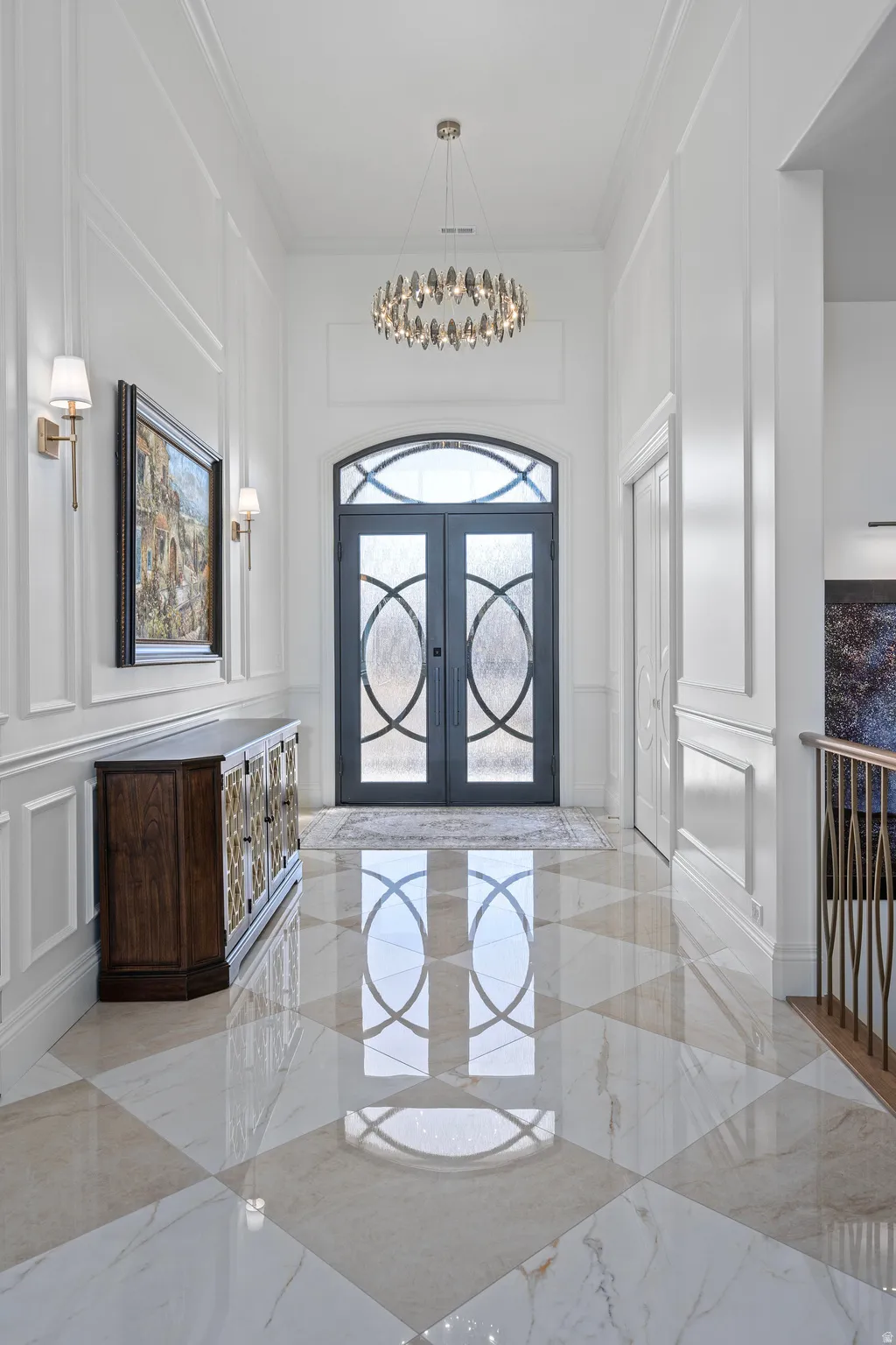 Entryway with a picture frame moldings,  custom rod iron double doors, light tile marble finish flooring