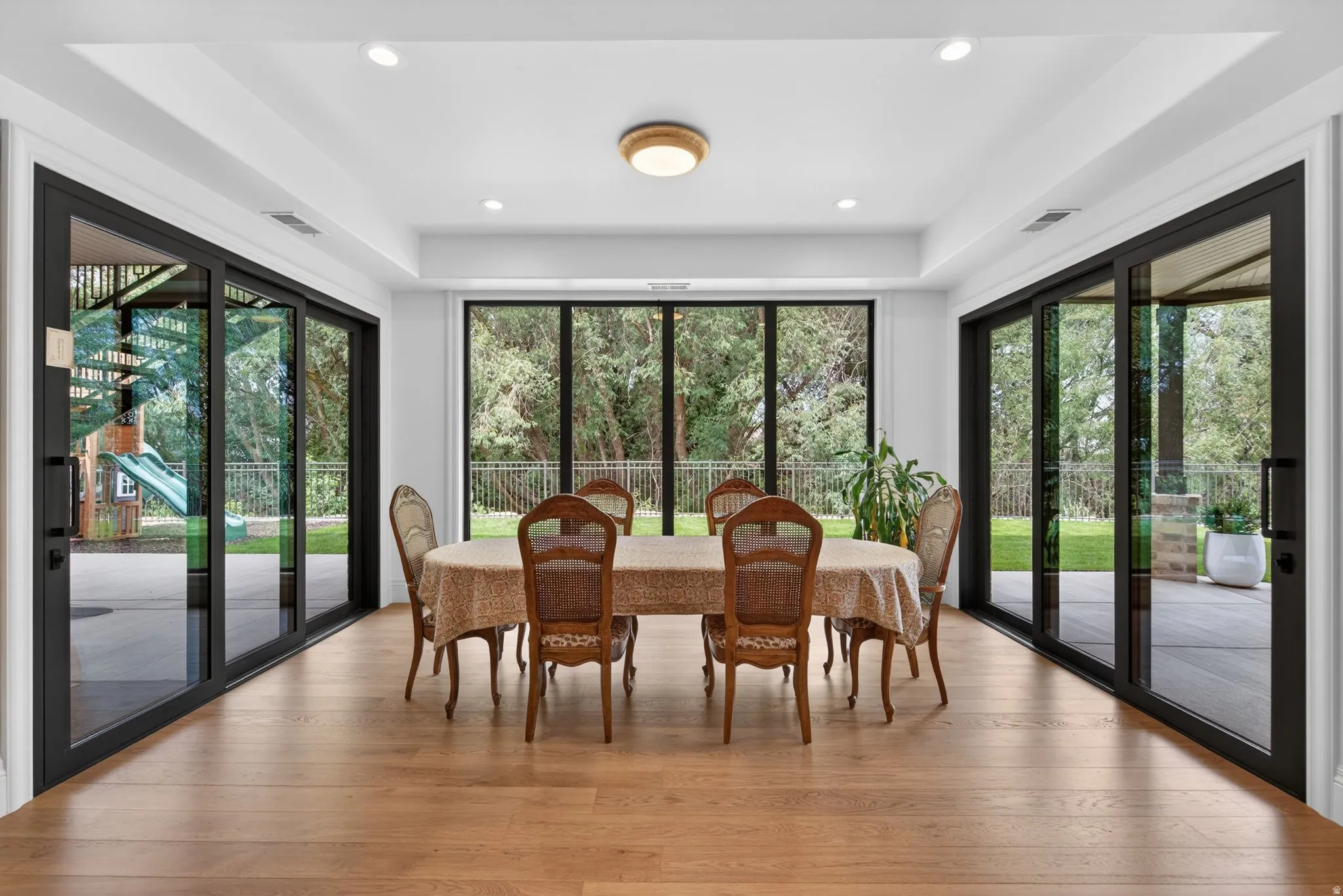 Spacious room with wood-finish flooring, recessed lighting, and a contemporary ceiling fixture