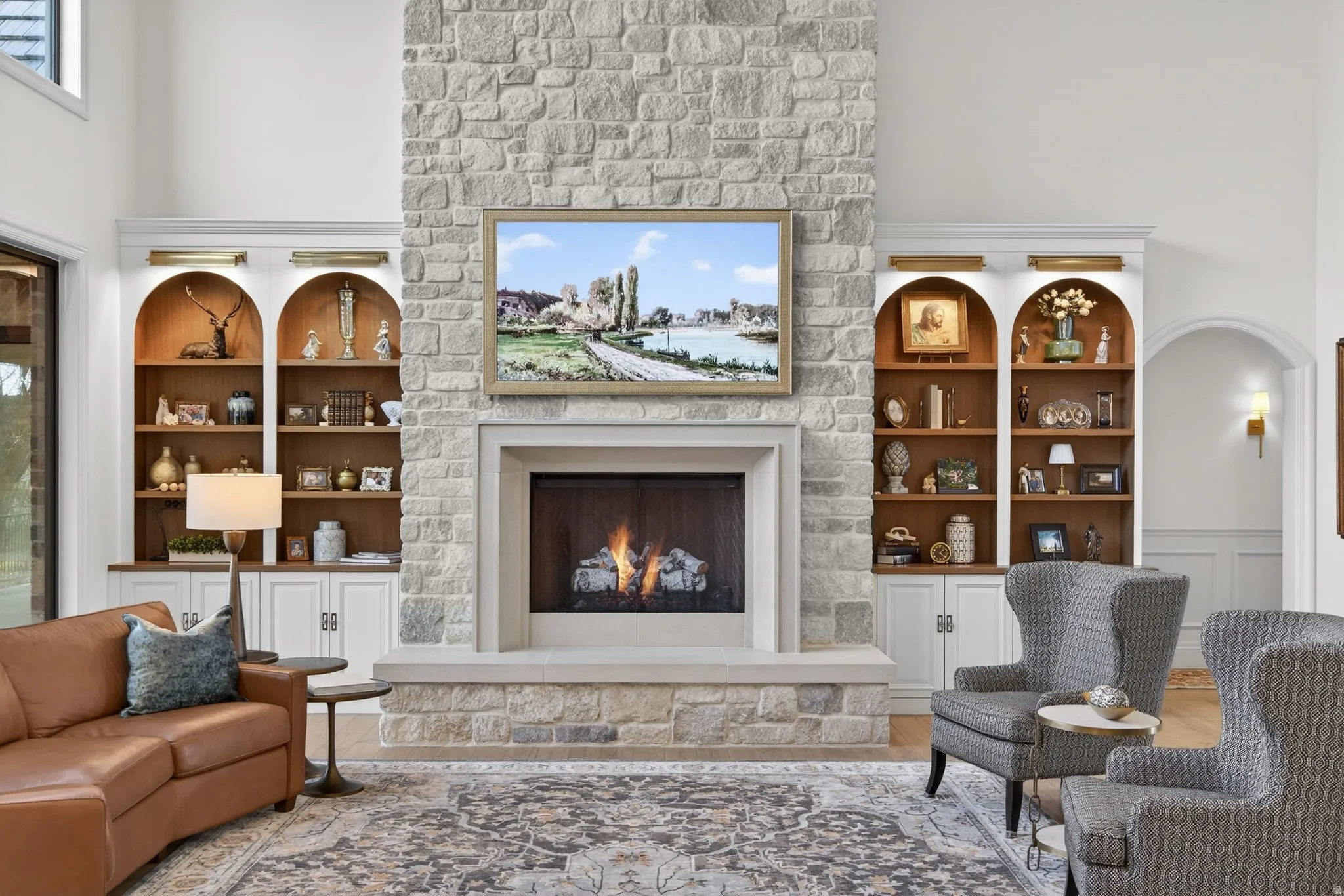 Living area with a fireplace, a towering ceiling, wood finished floors, built in shelves