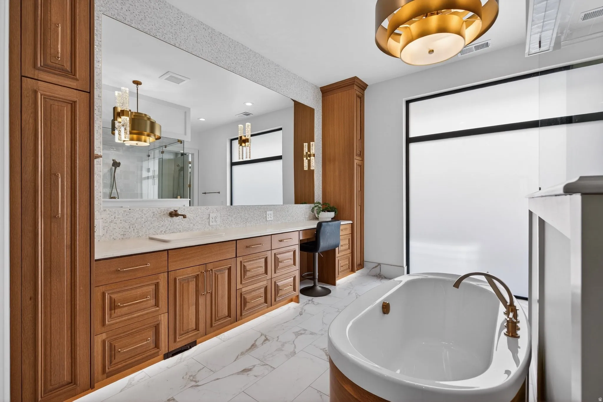 Primary Main Level Bath-mosaic tile around mirror, oak wrapped bathtub, foggable windows
