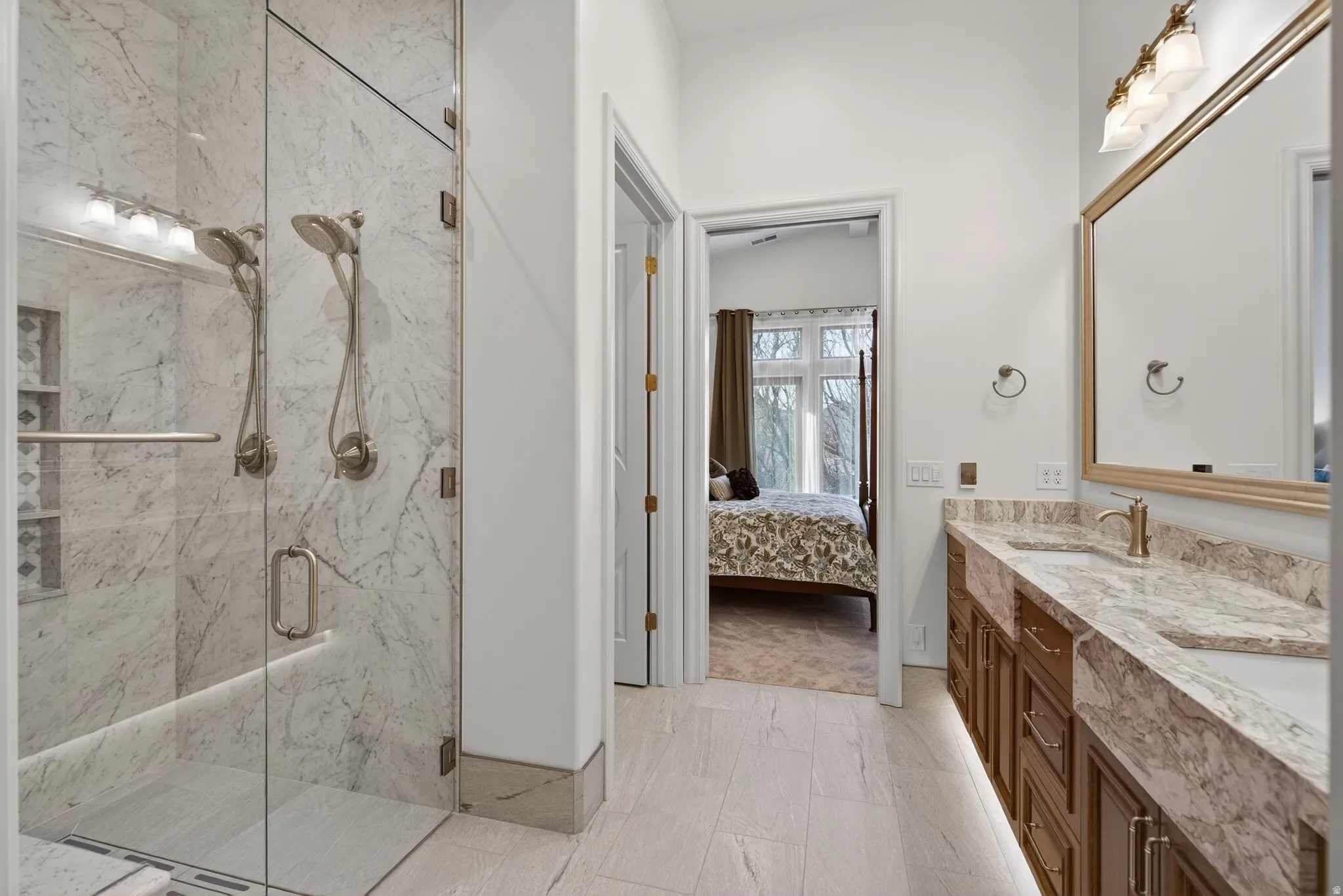 En suite In-law/Guest ADA bathroom featuring double vanity and a marble finish shower, heated floors